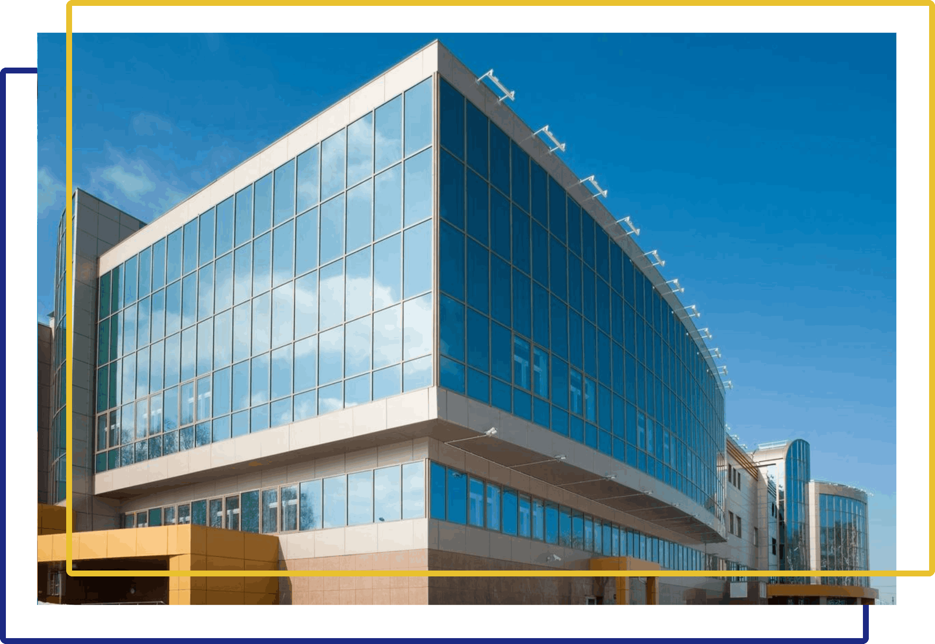 A large building with many windows and a yellow fence.